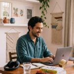 Joven latinoamericano escribiendo un correo de agradecimiento después de una entrevista de trabajo